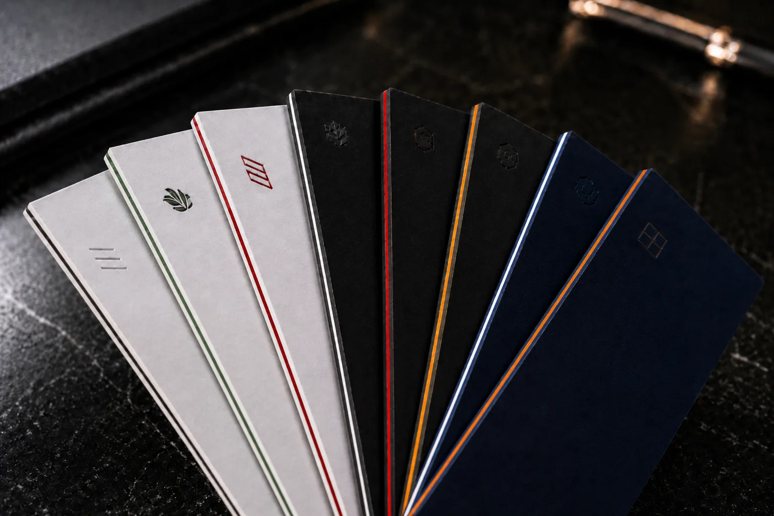 Angled fan of eight ultra-thick triplex business cards showing green, red, orange and blue core edges
