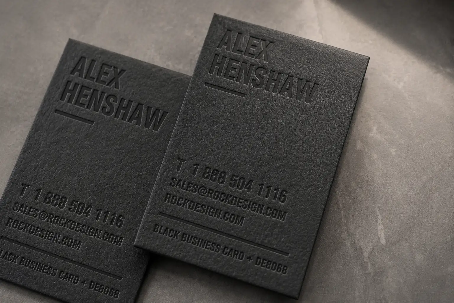 Black business cards with low-contrast blind deboss details and dark premium typography.