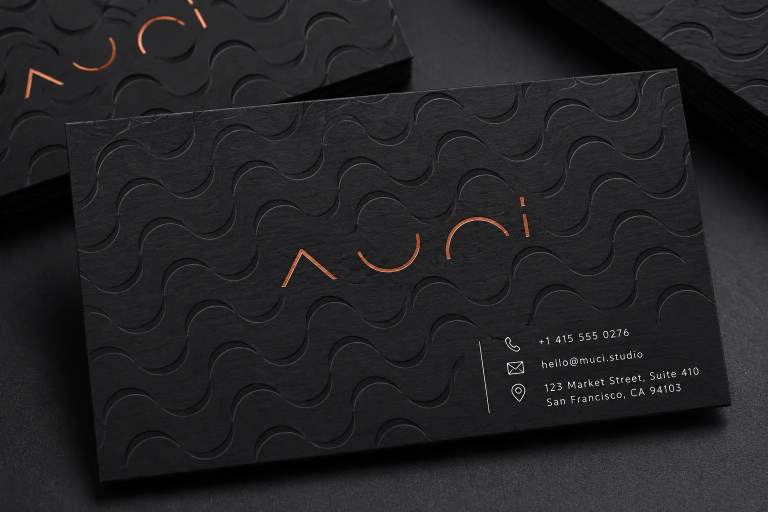 Matte black business card with glossy black spot UV wave pattern and small metallic accent details.