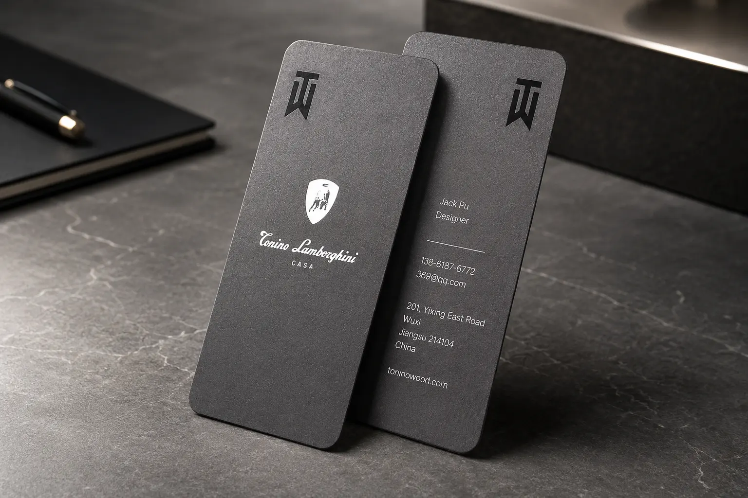 Vertical black business cards with restrained white ink and luxury brand mark details.