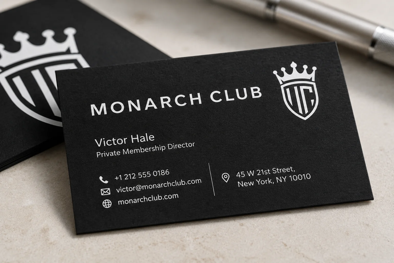 Black business card with crisp white ink typography and private club style layout.
