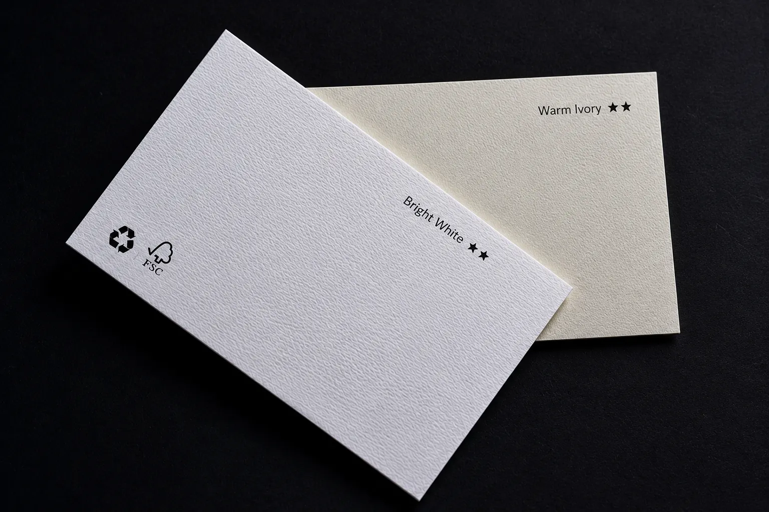 Bright white and warm ivory textured paper business cards showing natural paper color comparison