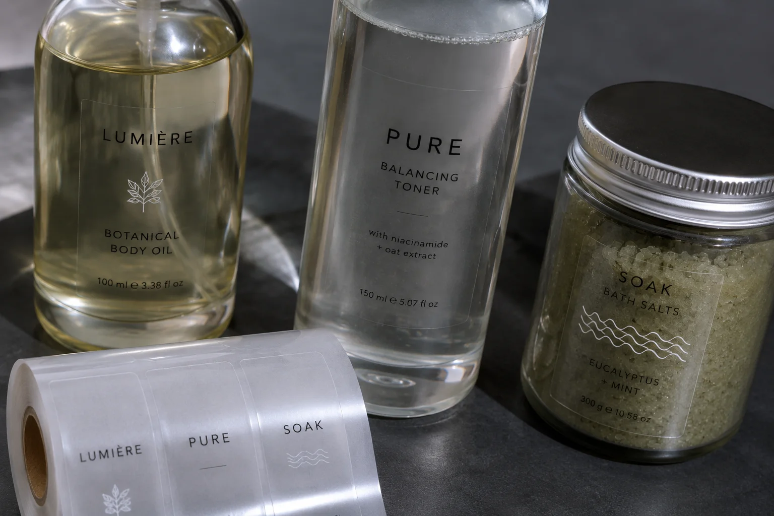 Transparent film labels applied to glass bottles with subtle label edges and white ink details