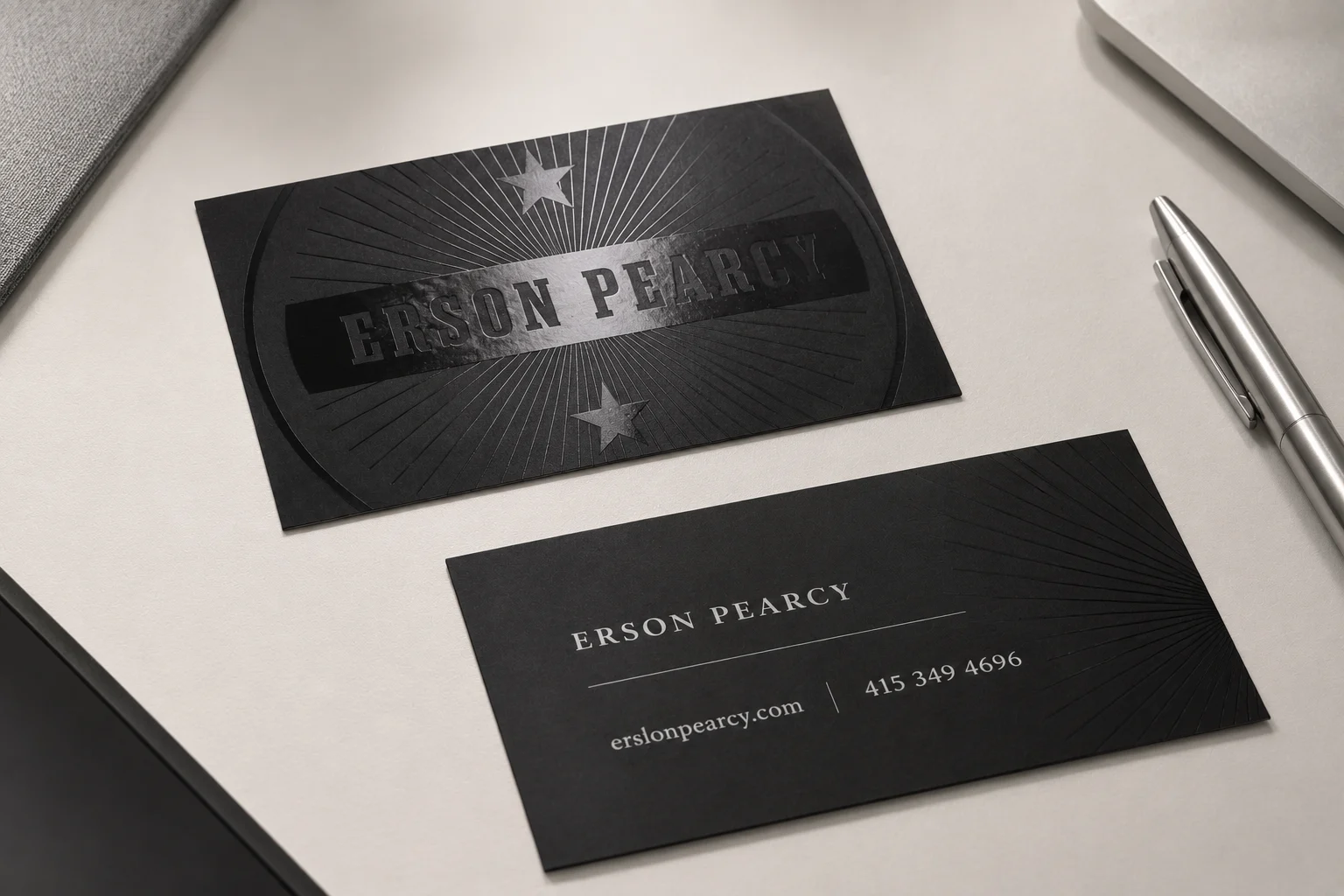 Black business card with clear spot UV logo detail on a matte surface