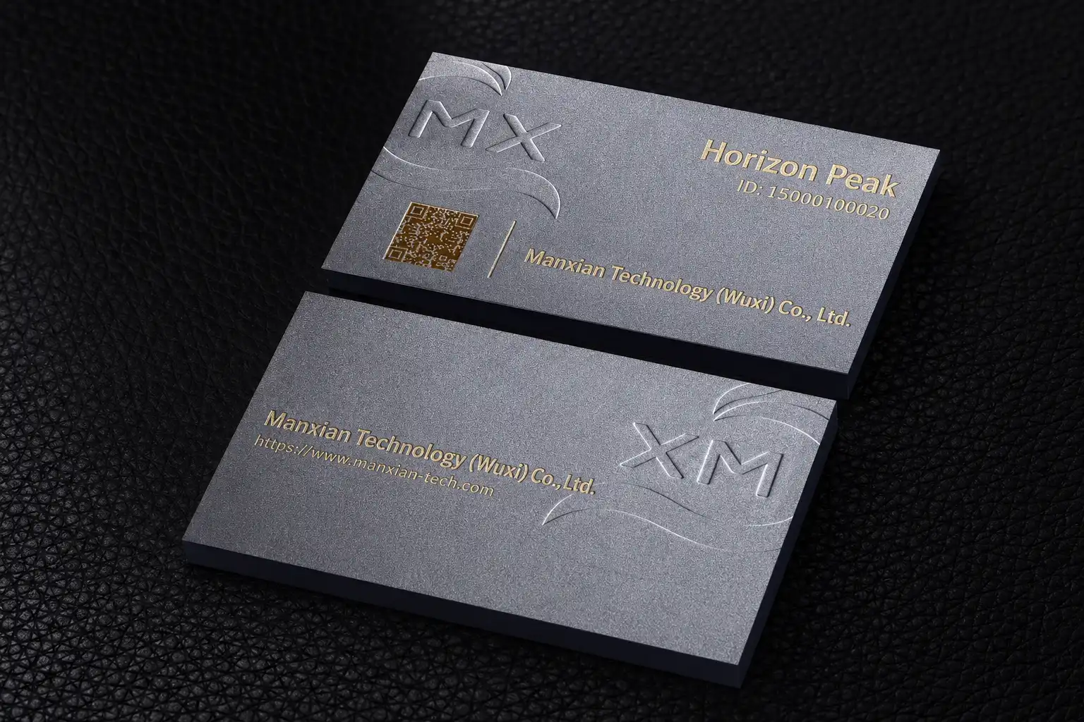 Cool grey business cards with subtle debossed artwork and small metallic foil details.