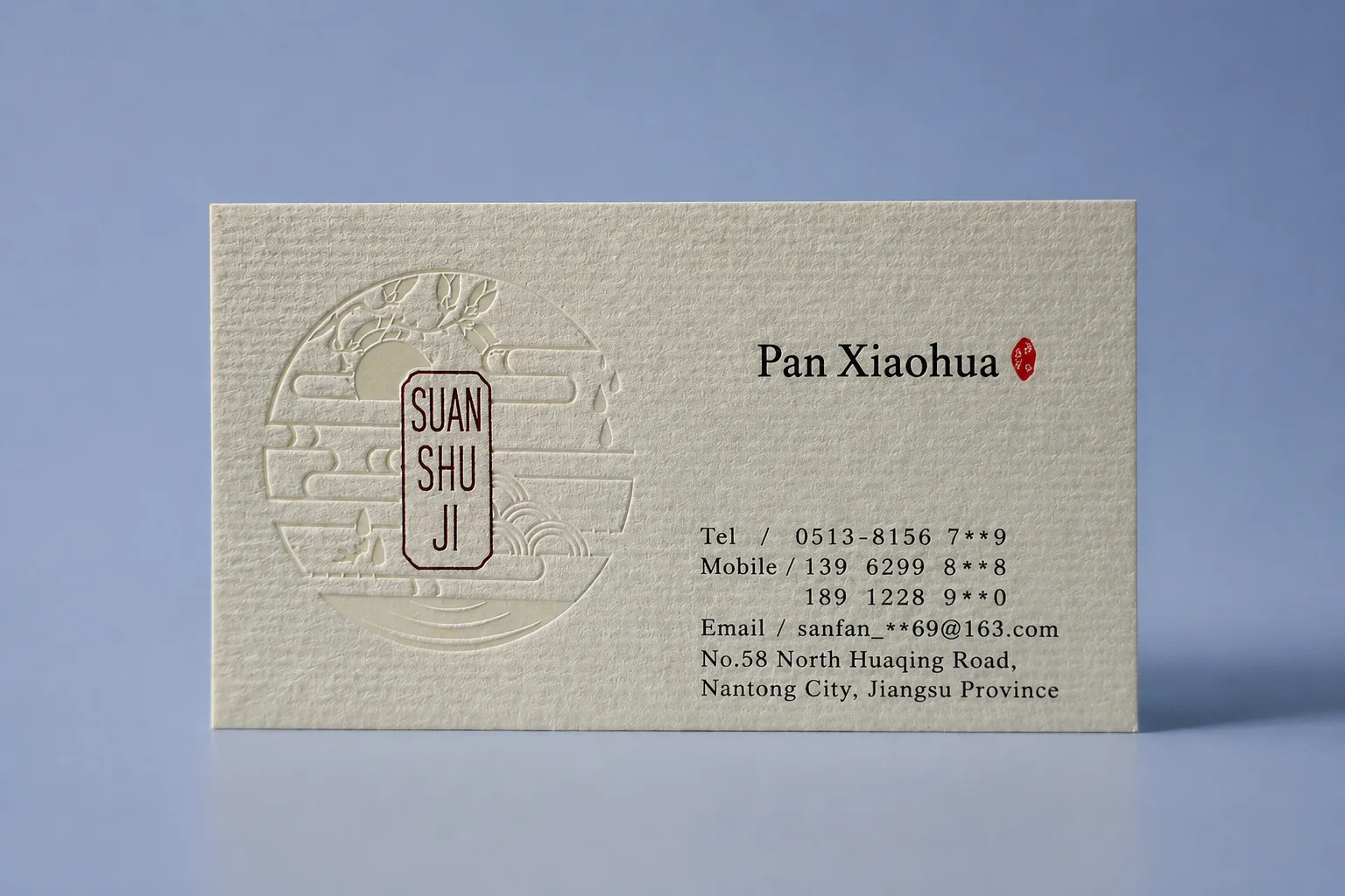 Cream laid textured paper business card with fine parallel surface lines and clean black printed contact details