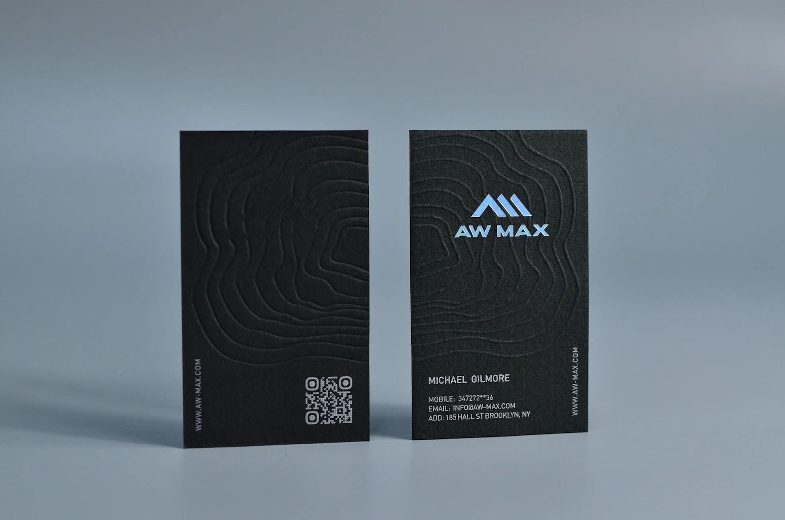 Dark FSC-certified recycled paper business cards with subtle texture and minimalist printing
