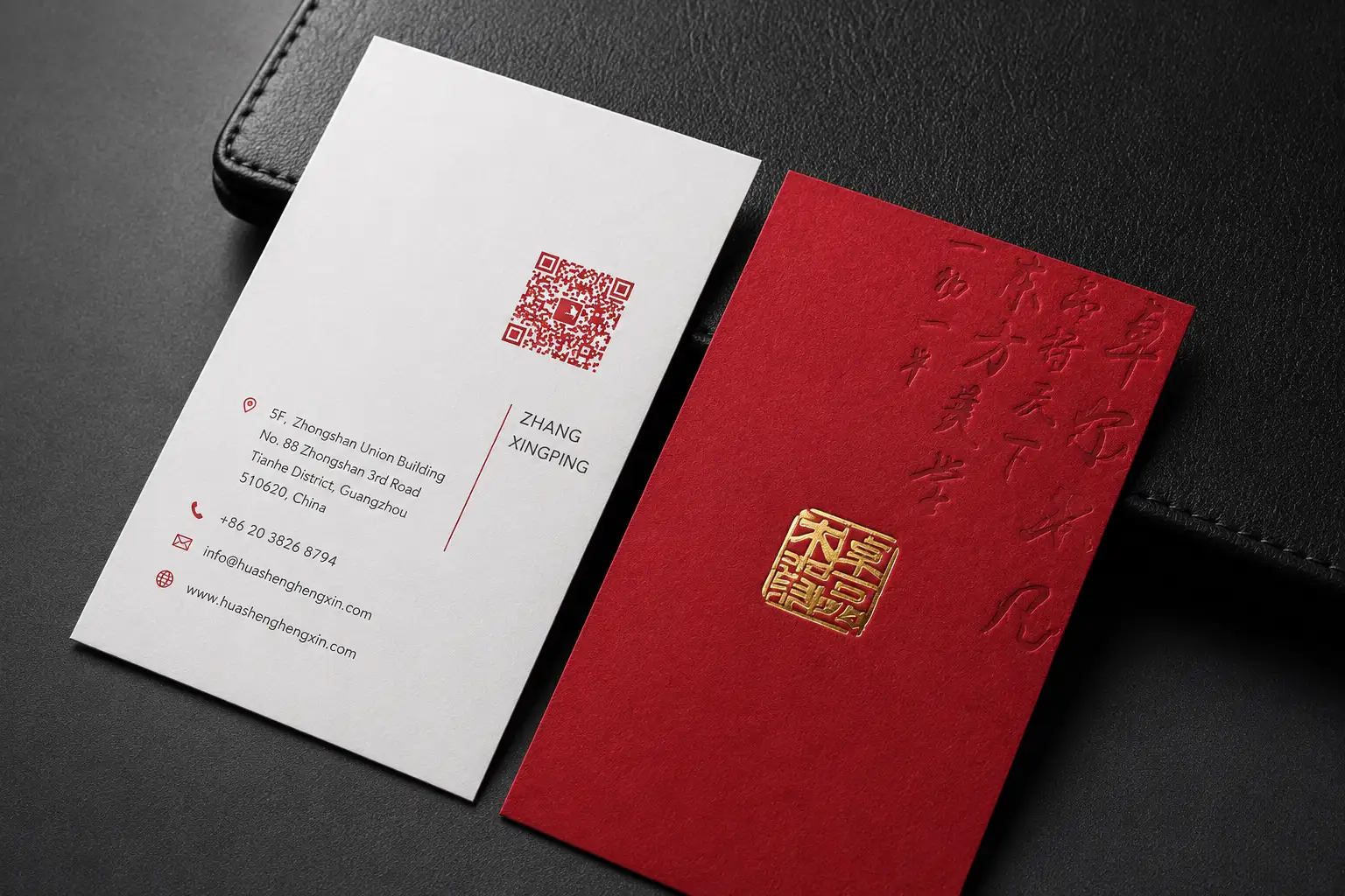 Red business card with pressed debossed texture and small metallic foil detail next to a clean white companion card.