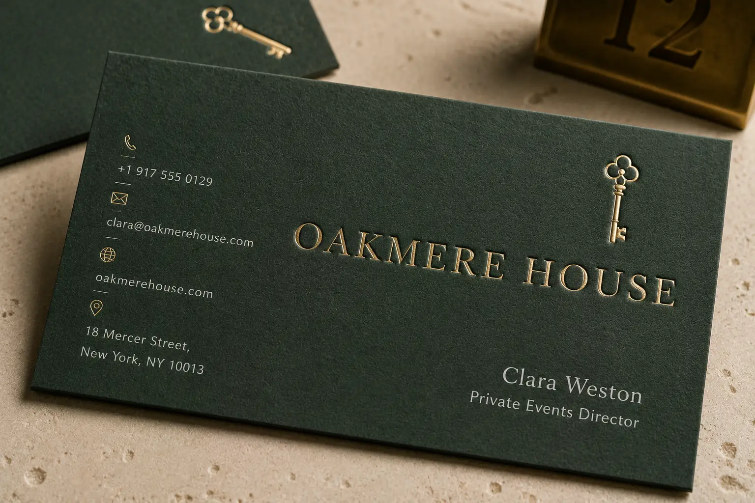 Forest green business cards with subtle debossed and metallic details for a premium hospitality brand.