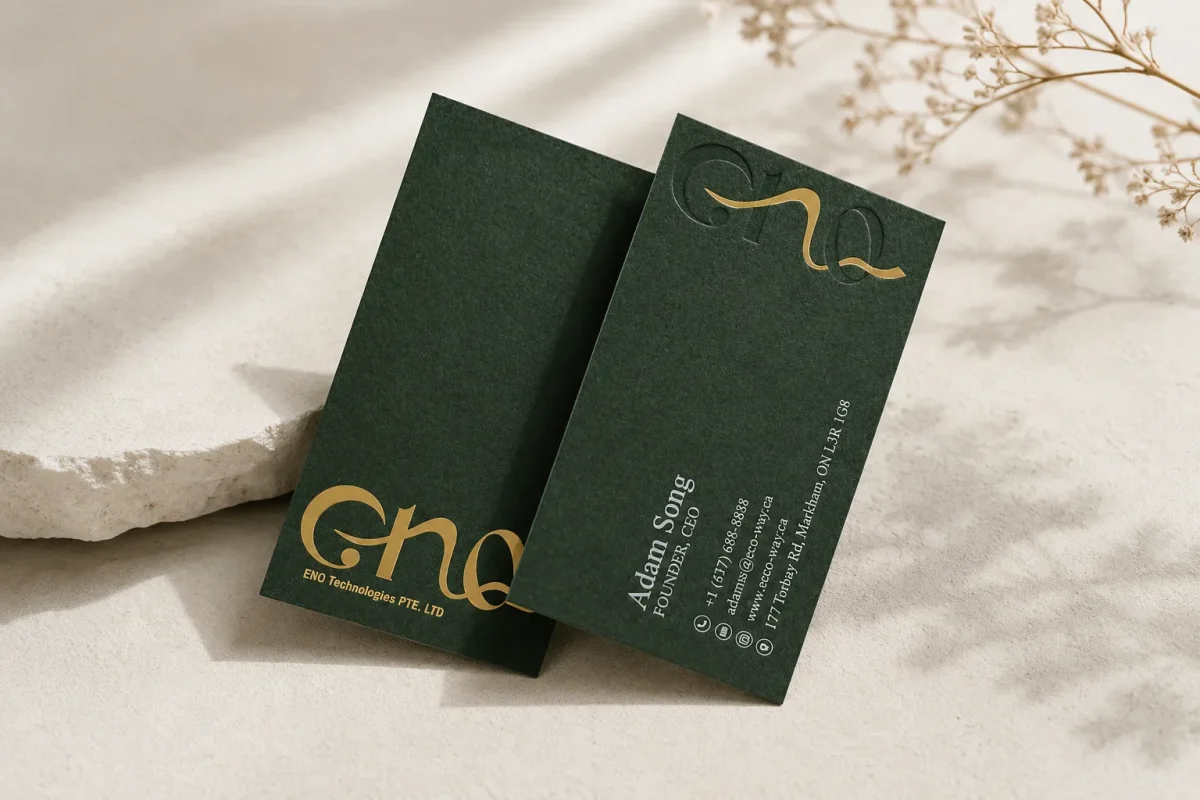 Forest green eco paper business cards with gold foil and readable light text.