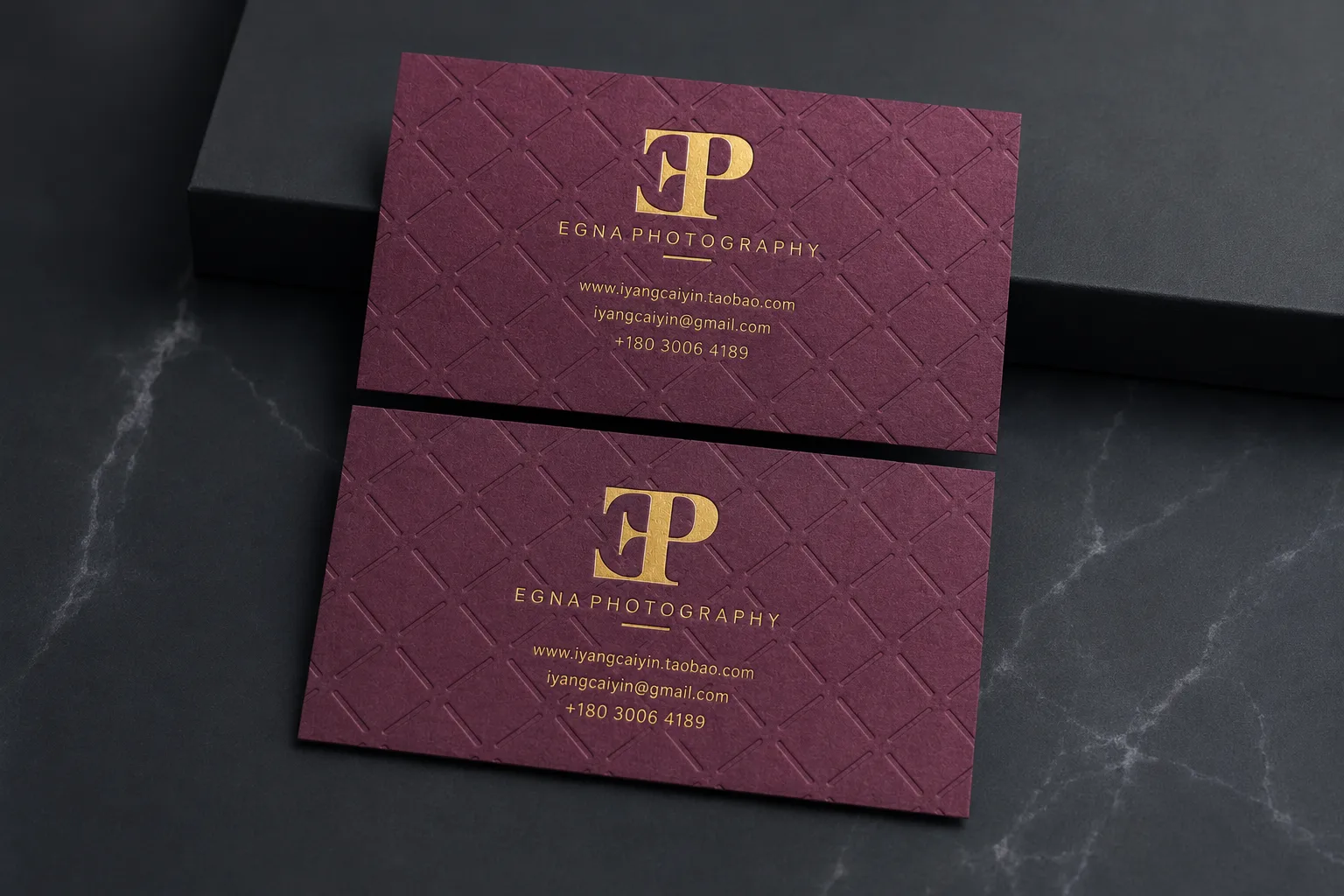 Burgundy business cards with gold foil monogram and subtle patterned foil-style background.