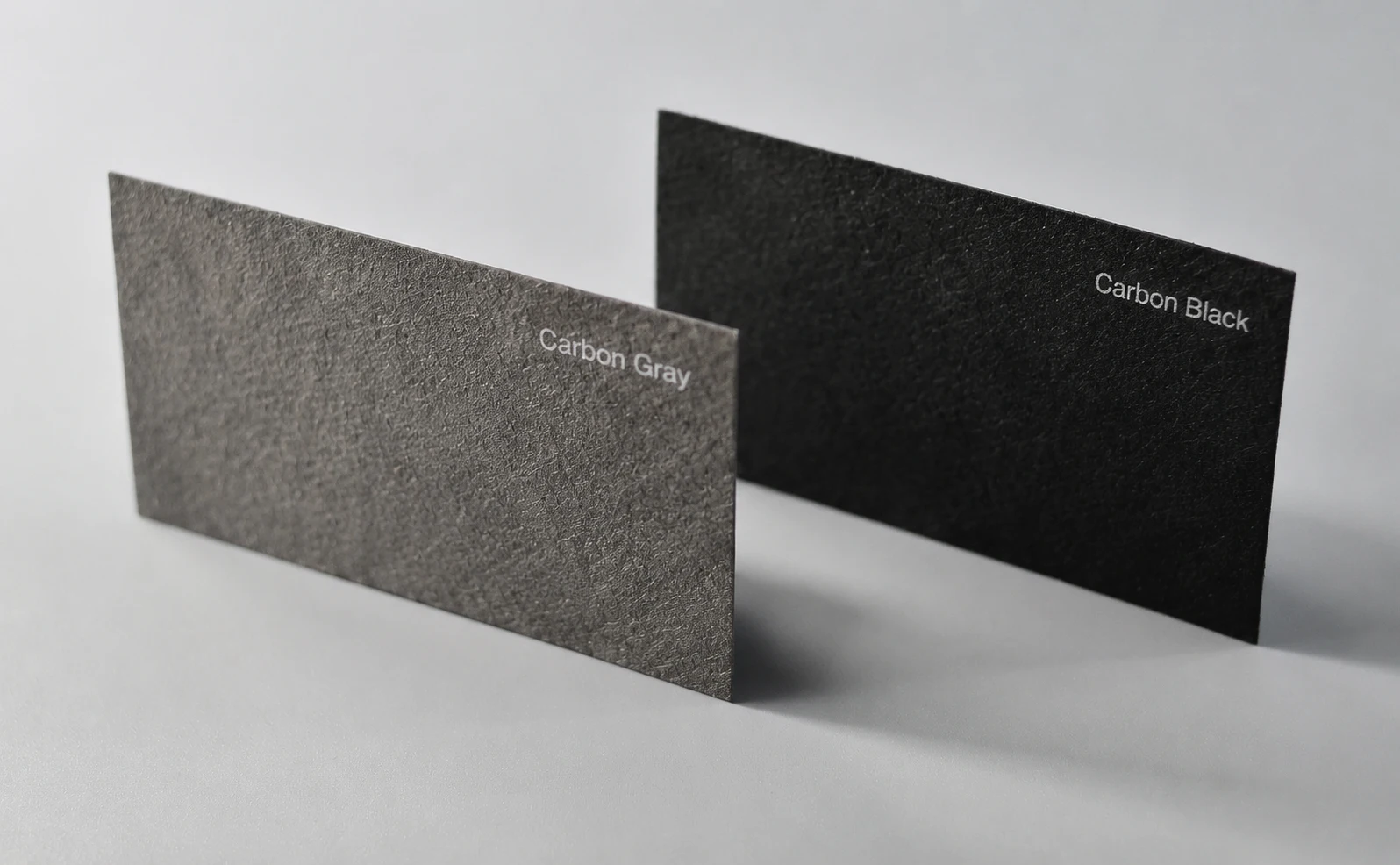 Grey and black FSC-certified recycled paper business cards showing natural texture and dark paper contrast