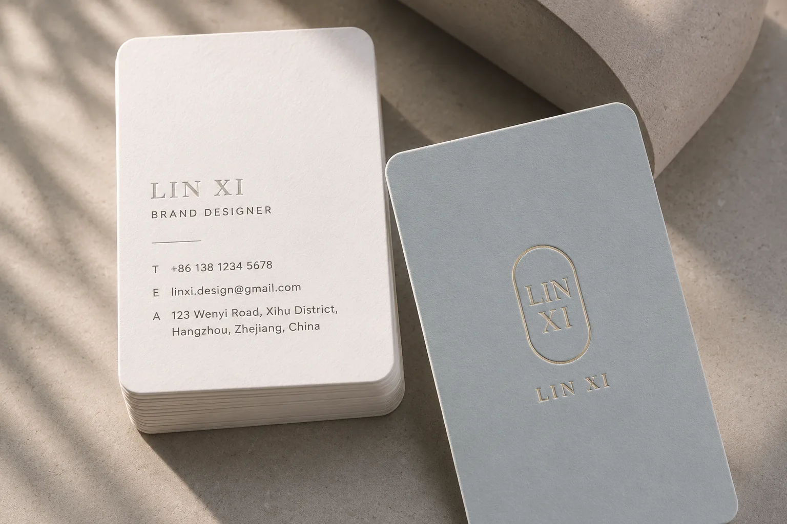 Minimal rounded corner business cards with subtle embossed logo detail and clean brand typography.