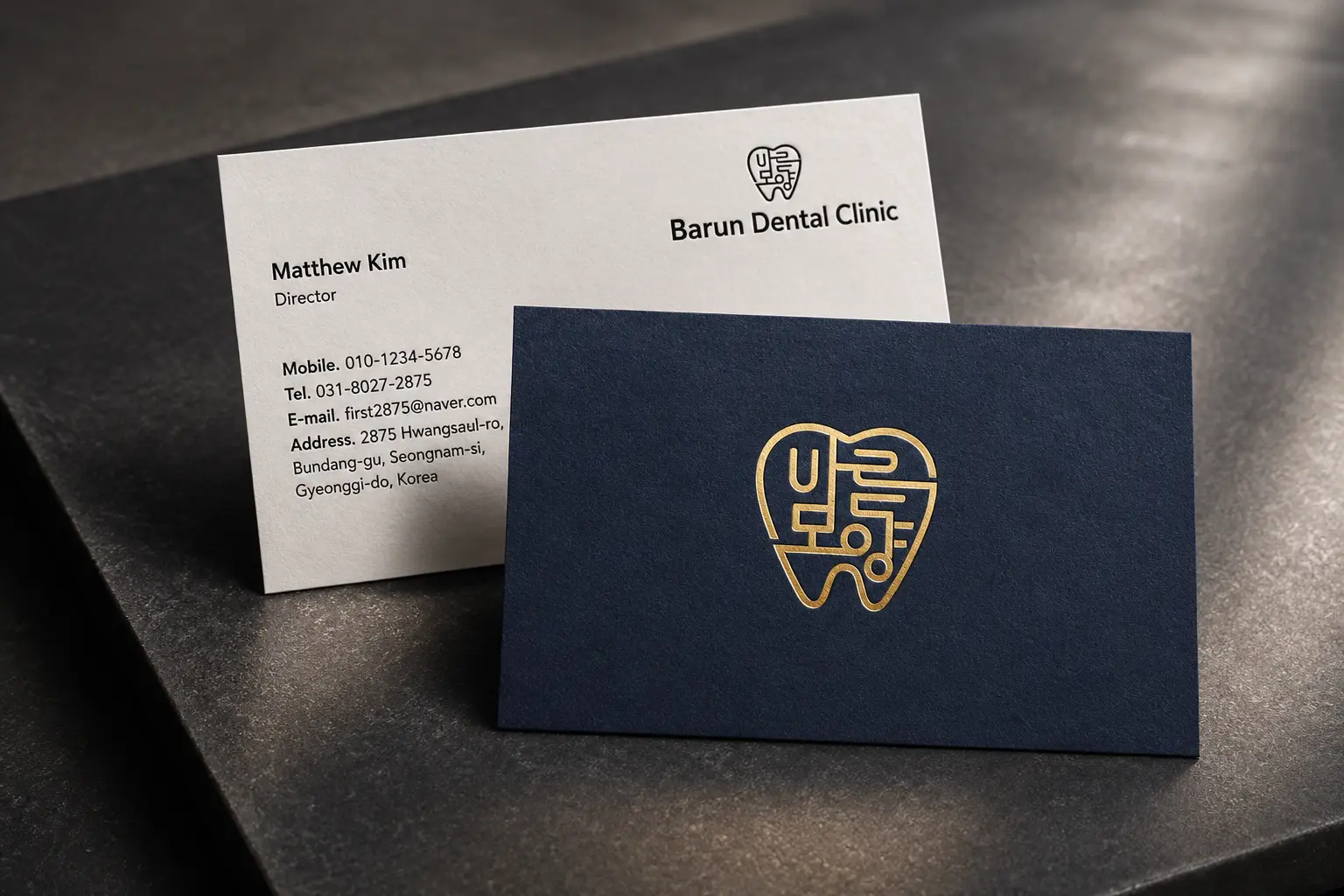 Navy and white clinic business cards with gold foil logo detail and professional healthcare branding.