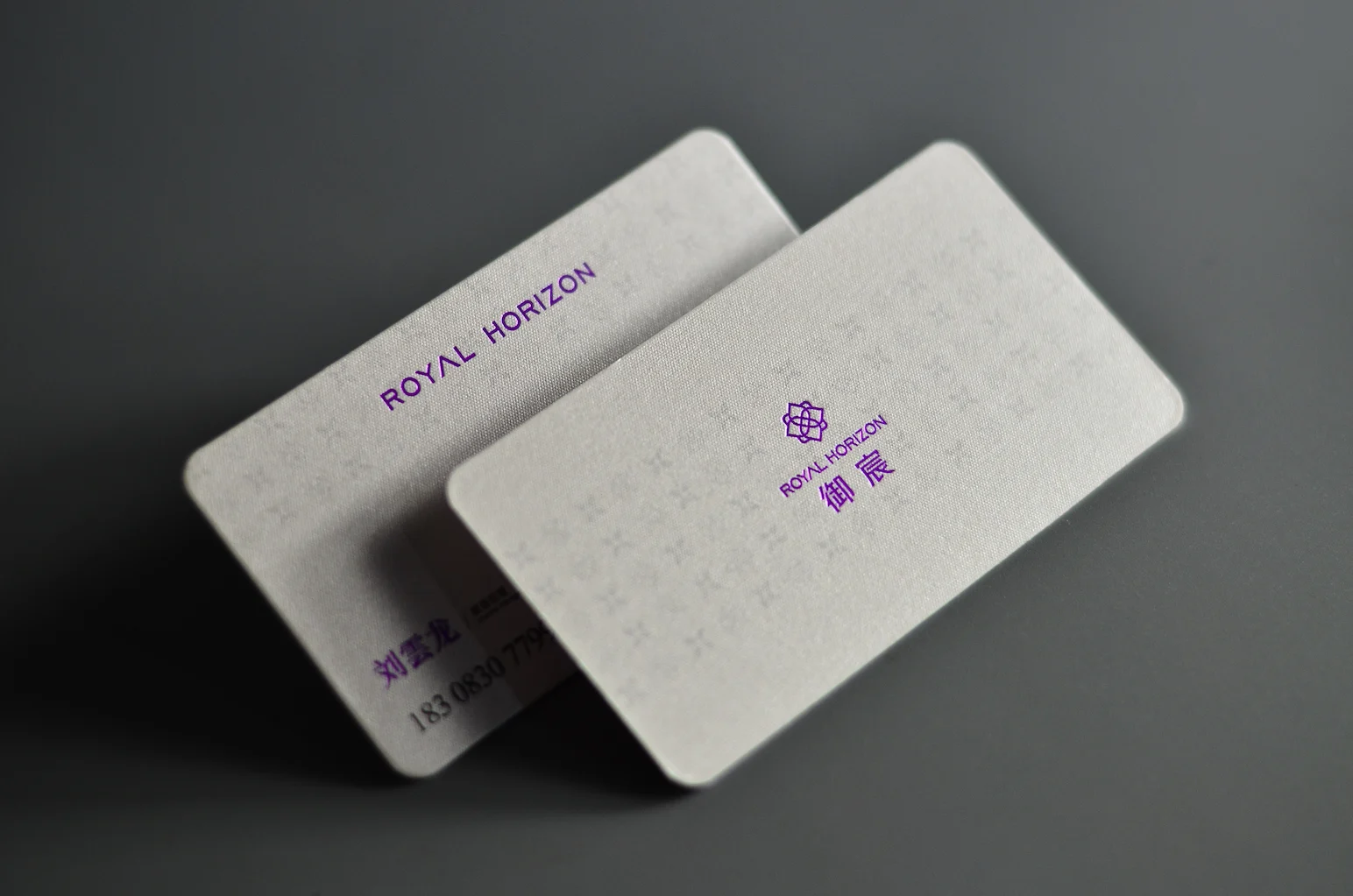Cream pearlescent business card with subtle gold signature detail