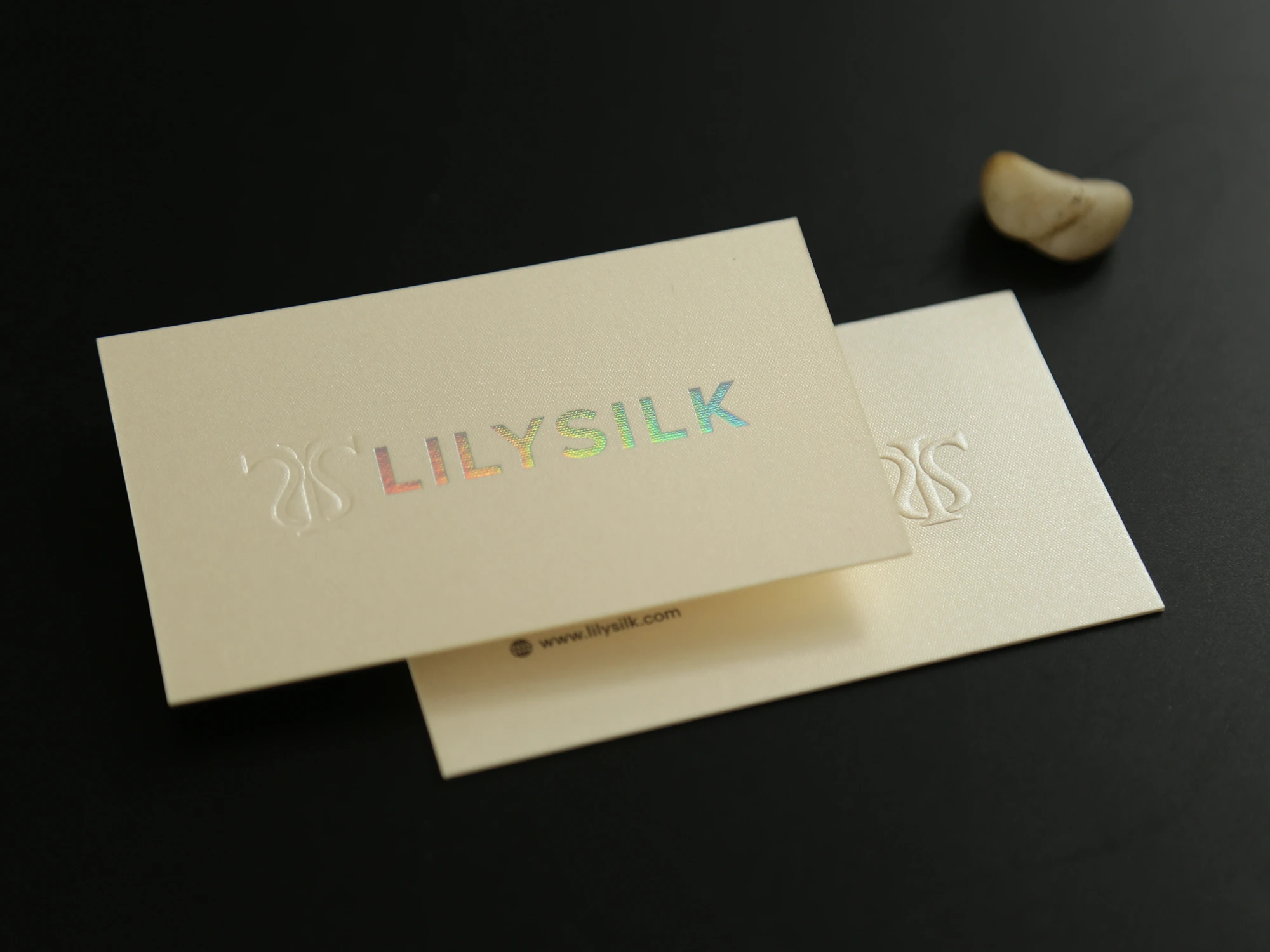 Ivory pearlescent business card with soft gold logo detail