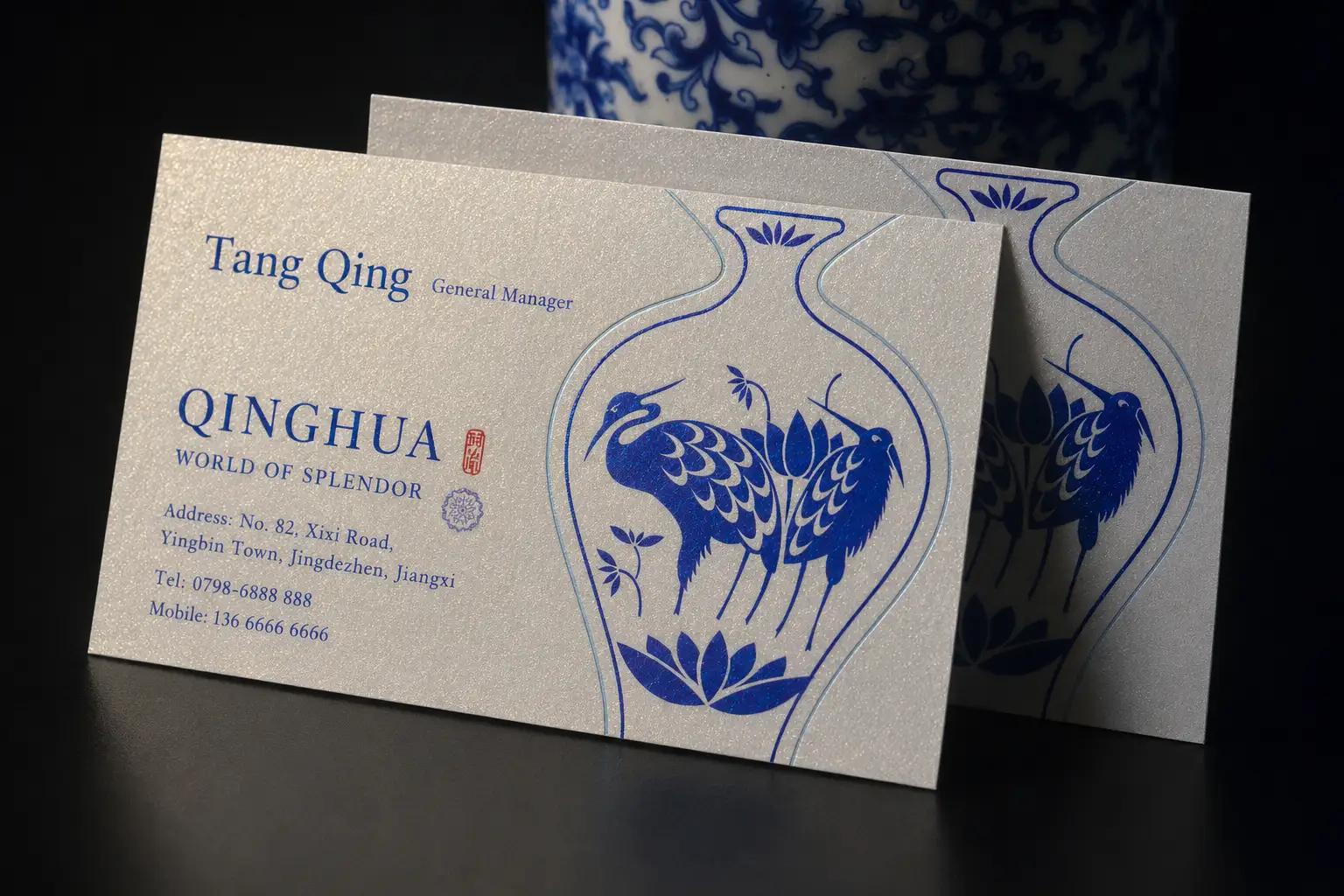 White pearlescent business card with blue illustrated pattern and folded display