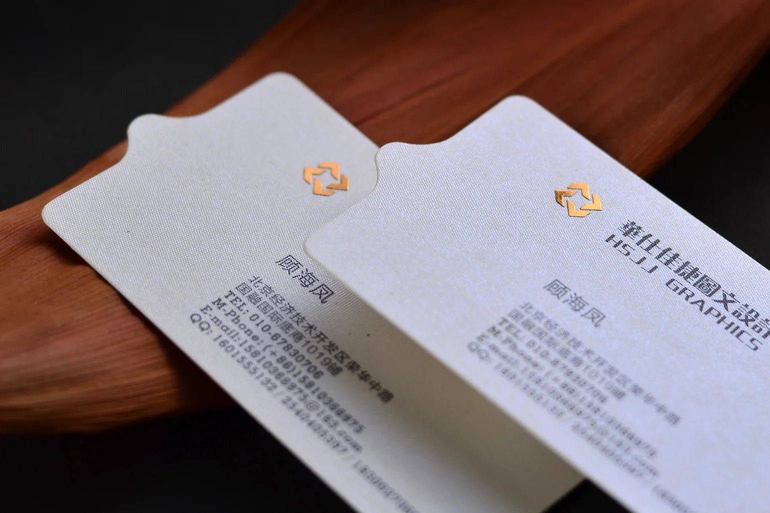 White pearlescent double-sided business cards with small gold logo detail