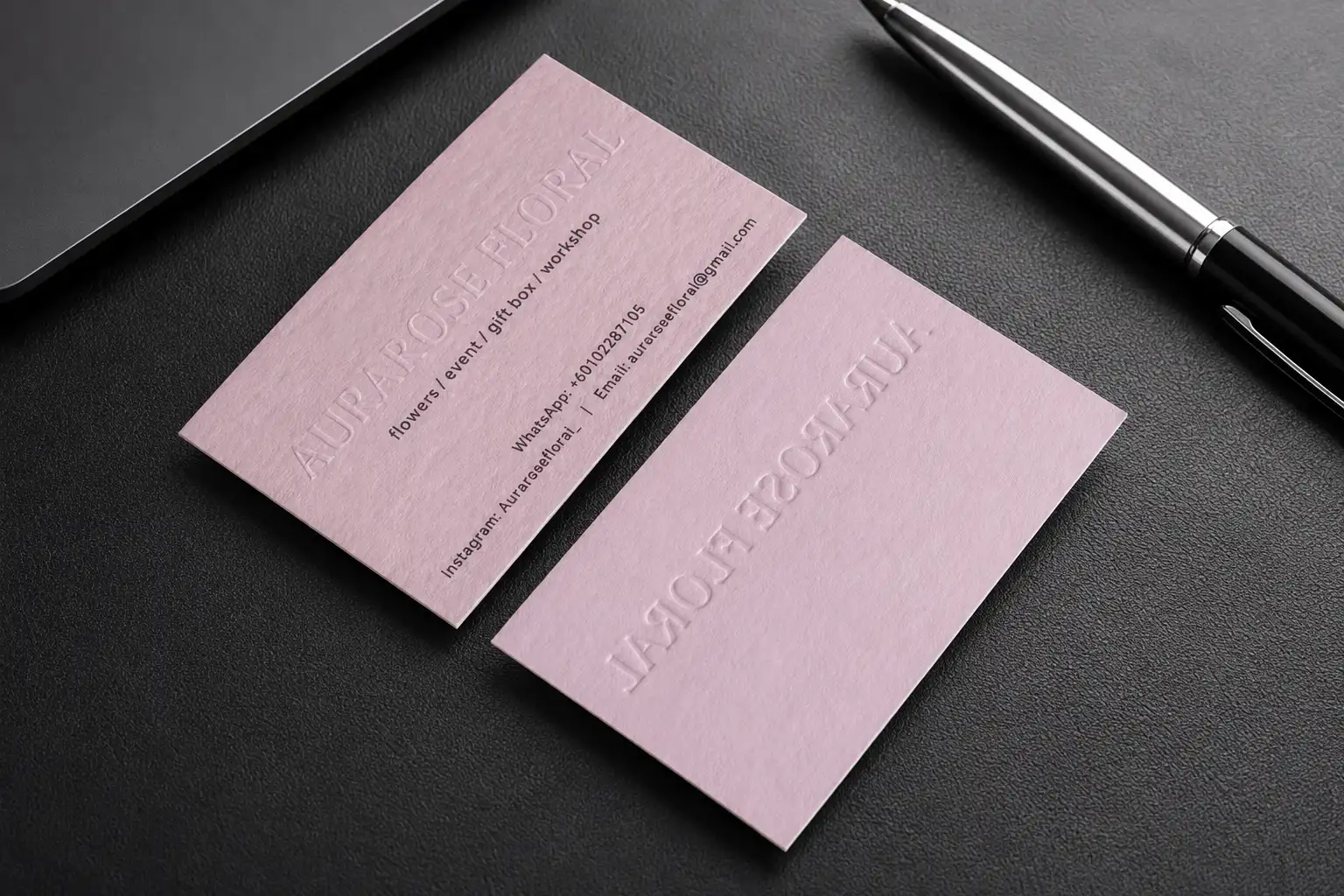 Pink minimal business card set with subtle debossed brand detail and clean studio-style layout.