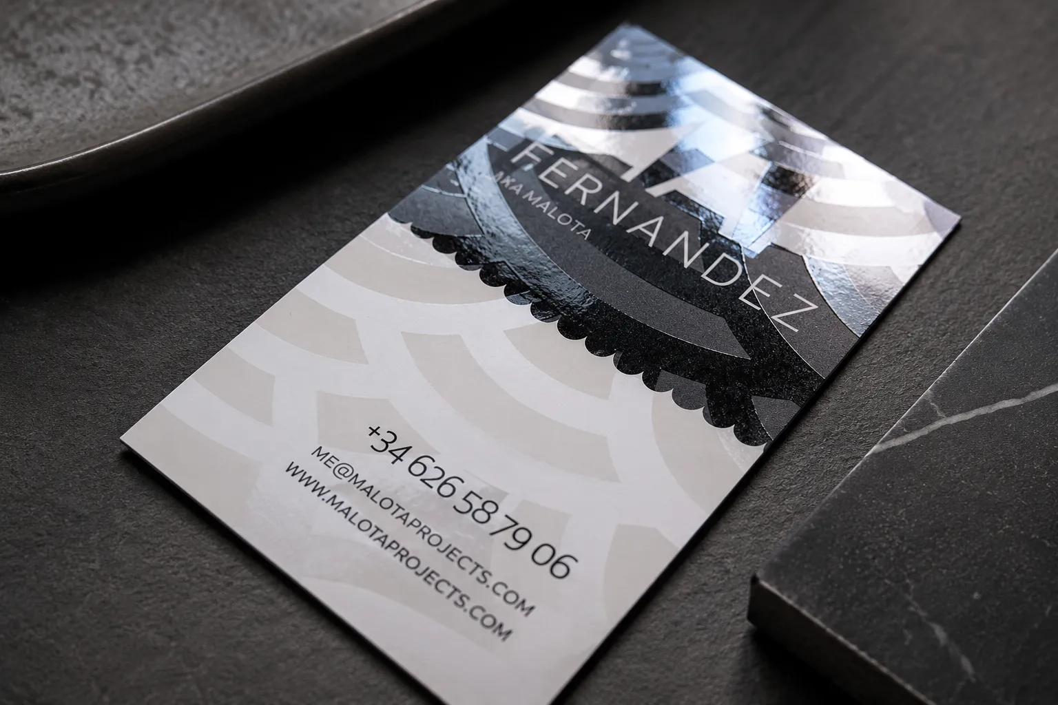 Premium business card detail with metallic foil accent and glossy surface reflection
