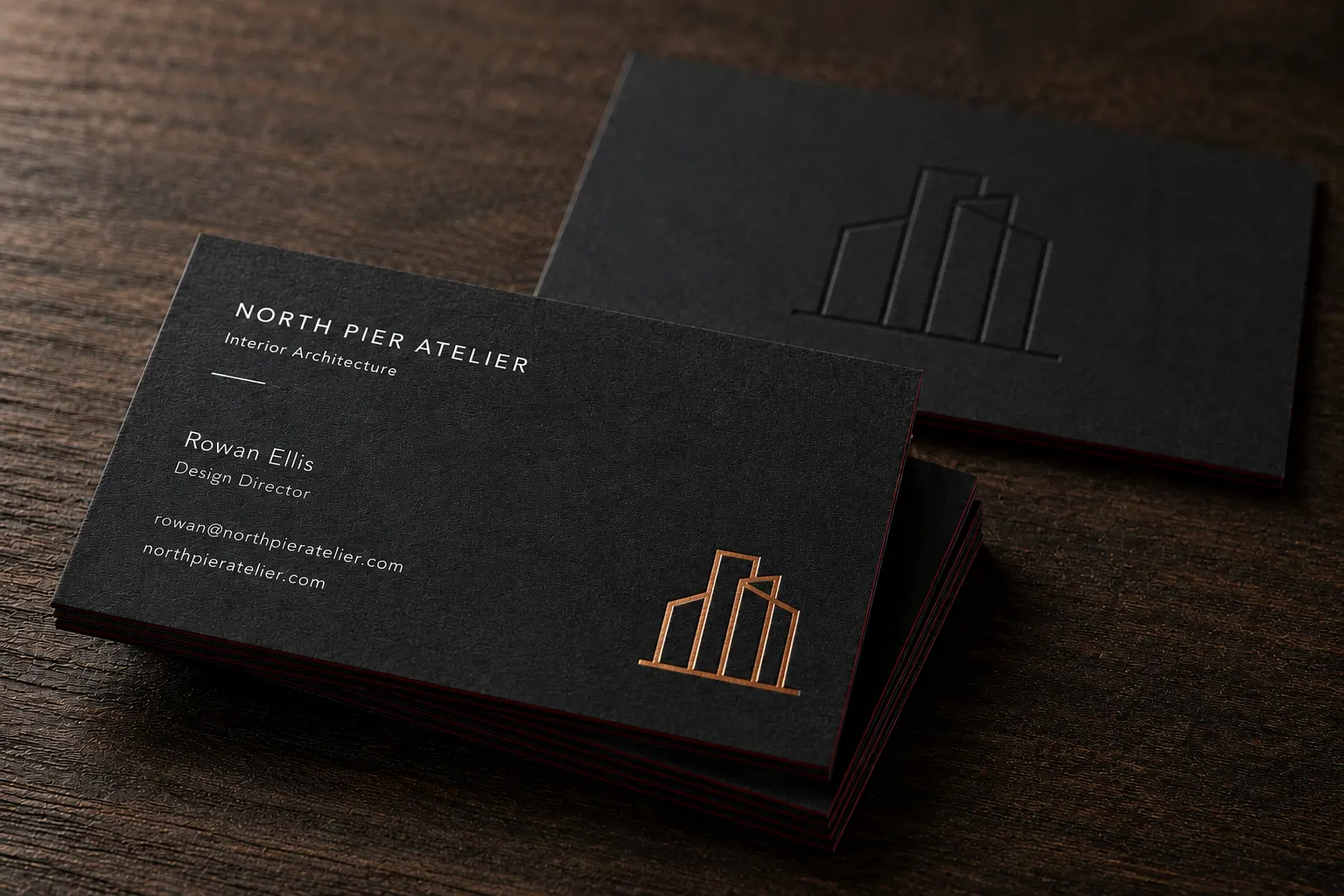 Thick black duplex business cards with visible paper edge structure and a subtle colored core line.