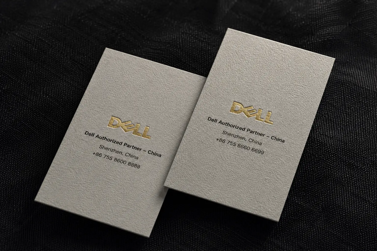 Warm ivory textured paper business cards with gold printed logo and refined uncoated paper surface