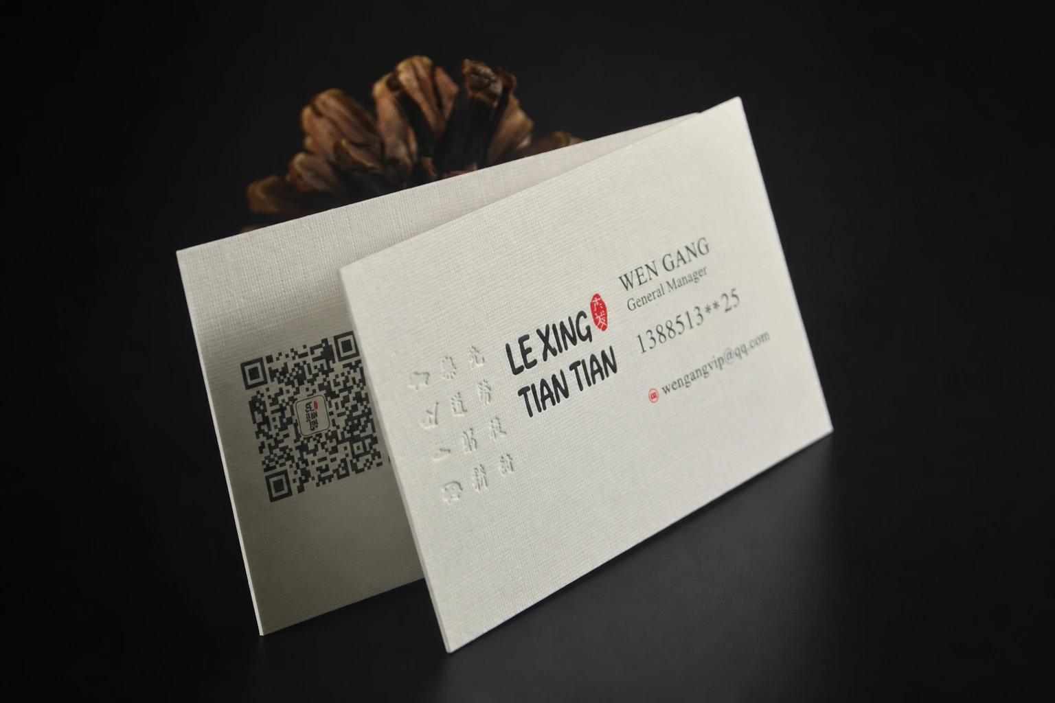 Warm white textured paper business card with QR code, minimal typography and premium uncoated paper surface