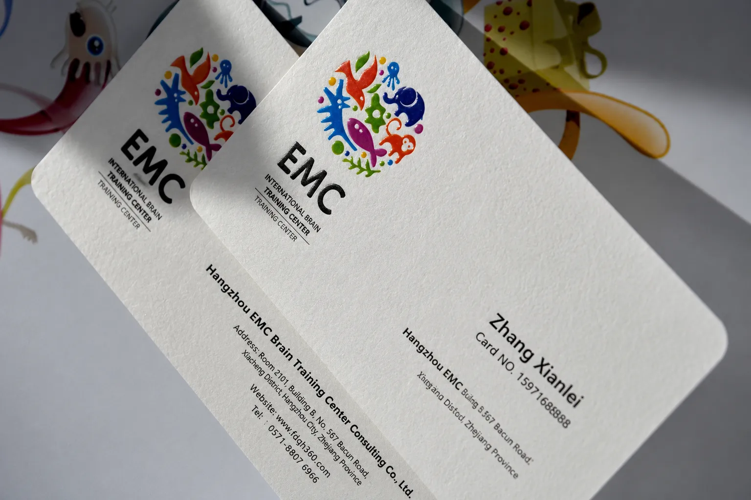 White business cards with colorful printed artwork and glossy finish detail