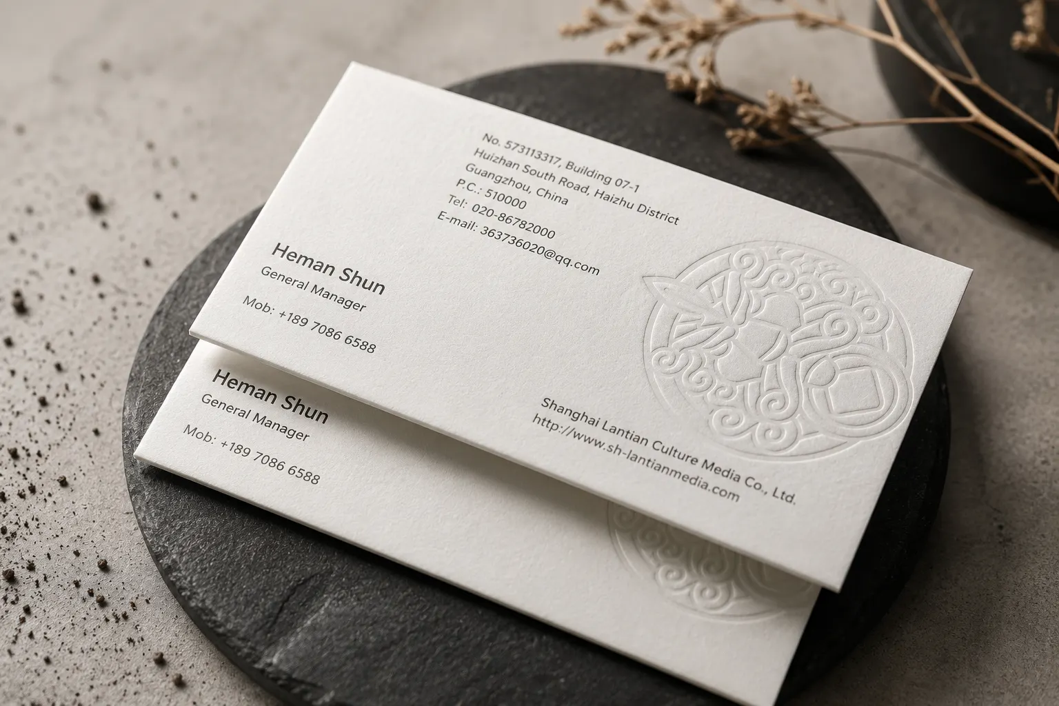 White cotton business card with a large blind deboss illustration and refined letterpress style typography.