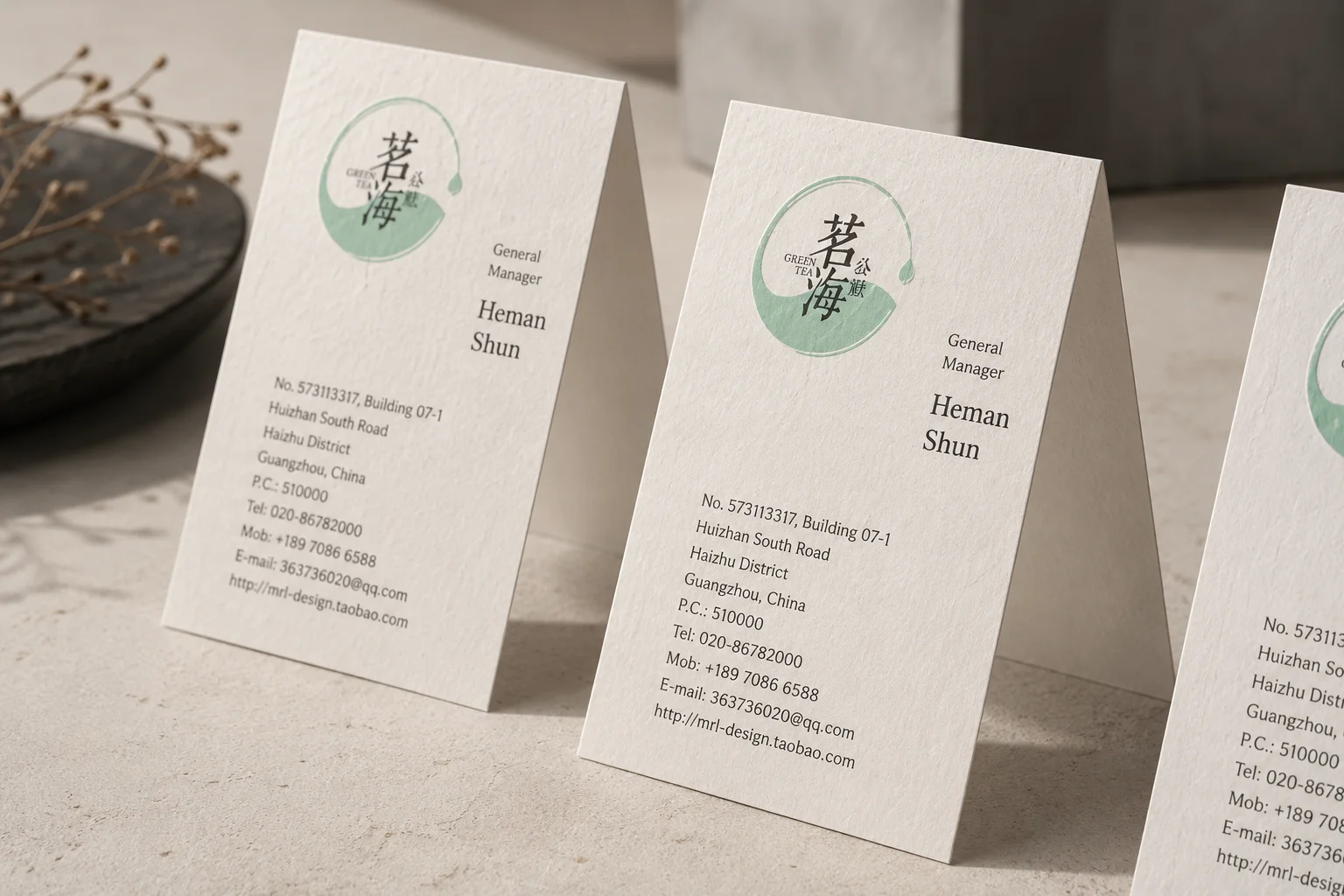 White cotton business cards with green letterpress details and clean vertical stationery layout.