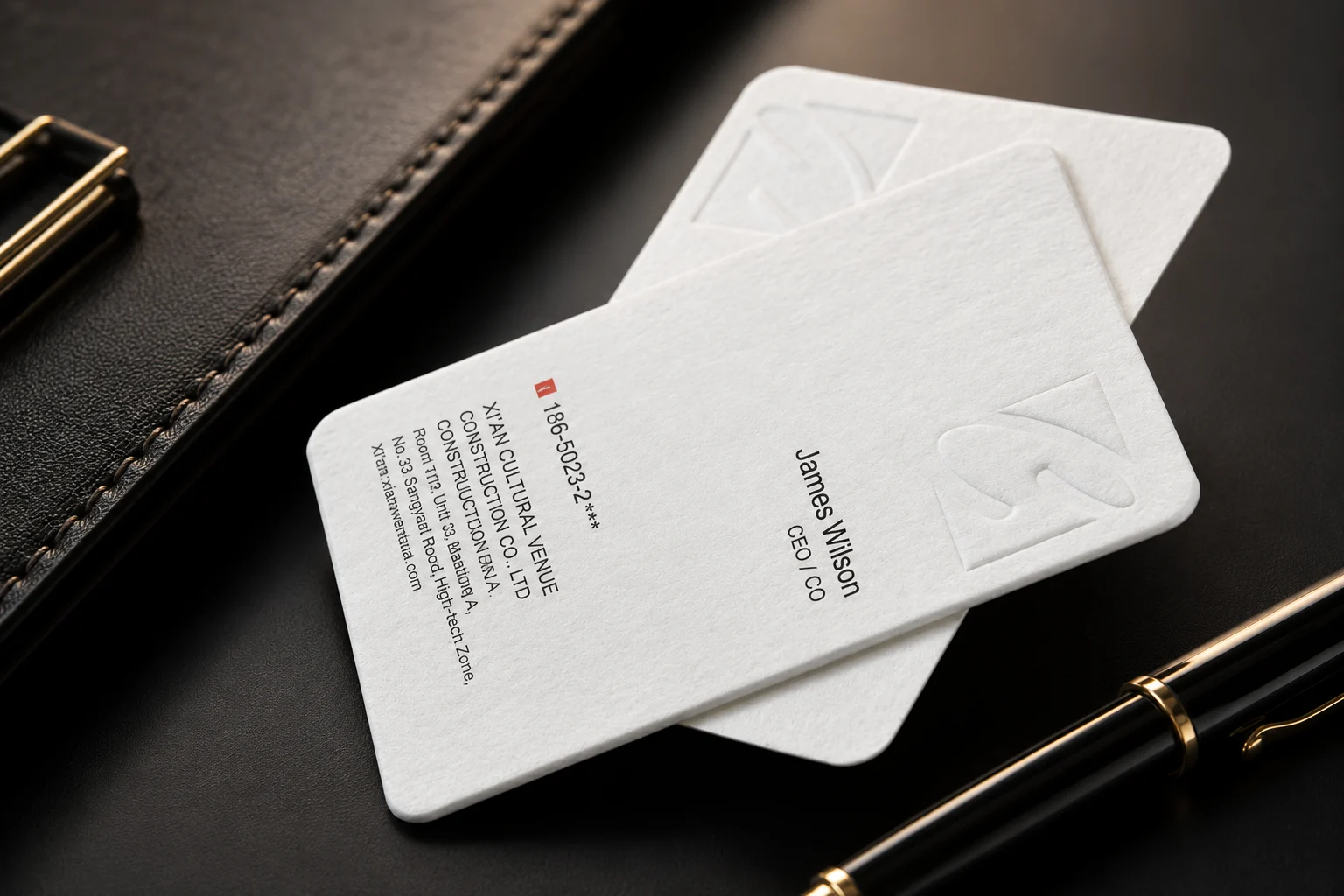 White rounded corner business cards with subtle embossed detail and clean die cut edges