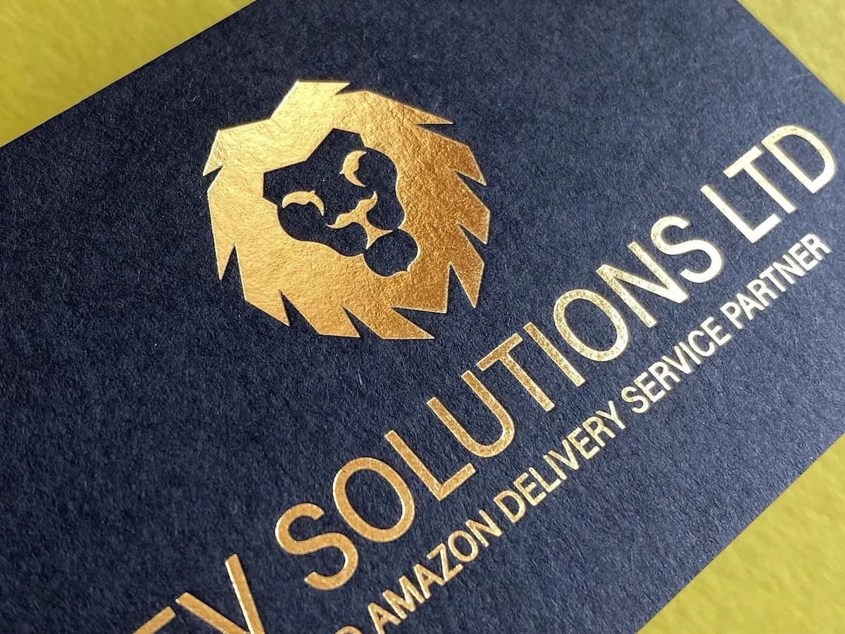 Close-up of a black cardstock business card with gold foil stamping.