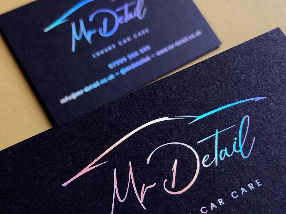 Black cardstock business cards with holographic foil stamping.