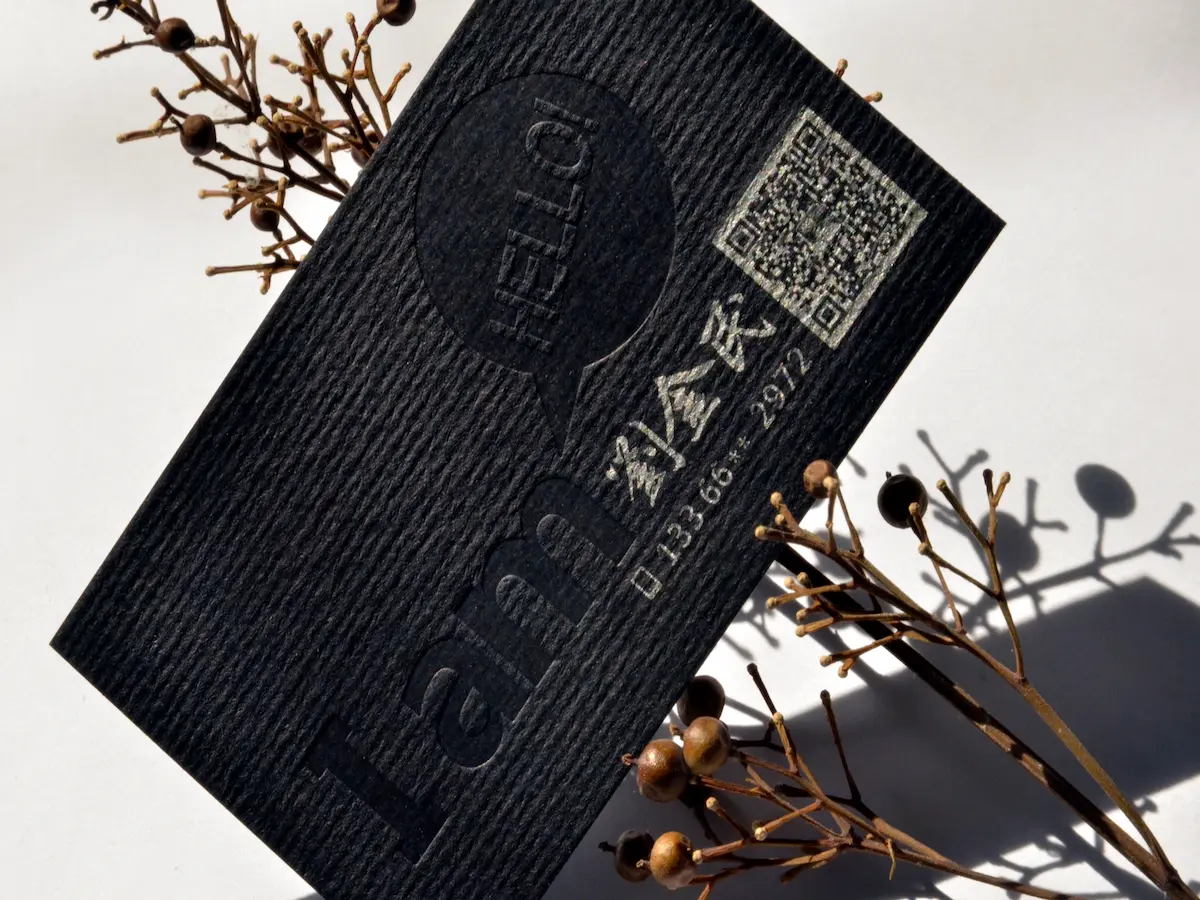 Two textured black cardstock business cards with blind embossing and light-colored contact details.