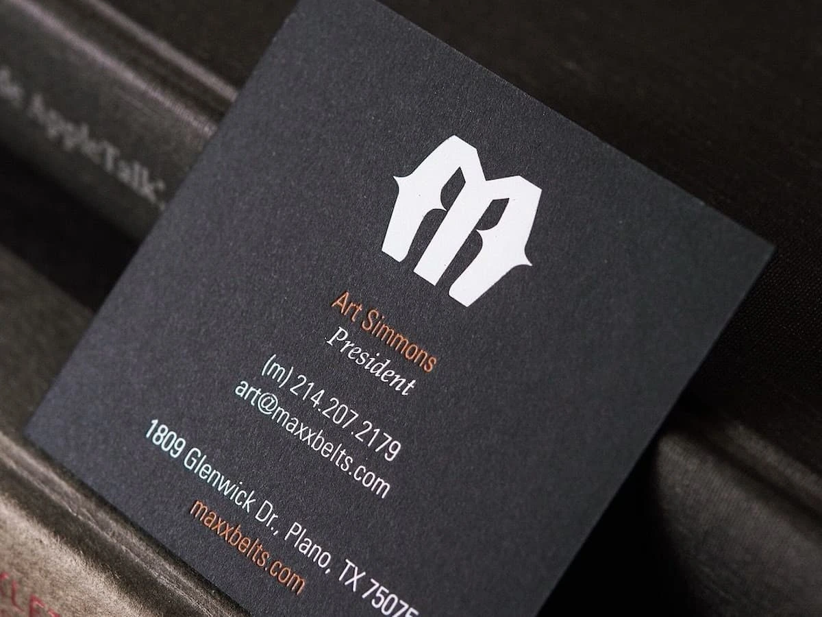 Black cardstock business card with white gold foil stamping.