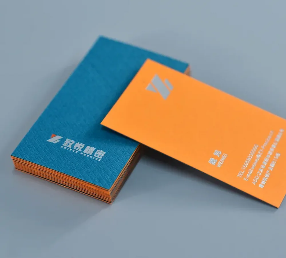 Blue and orange business cards with visible orange edges and light-colored lettering
